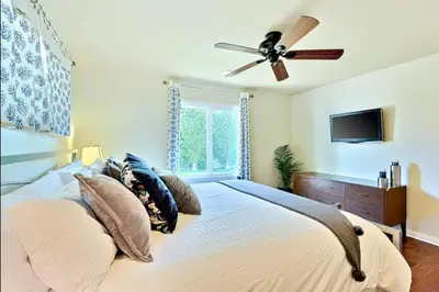 a bedroom with a bed with a ceiling fan at Sandy Shores Beach House in San Diego