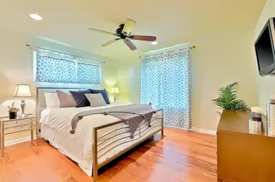 a bedroom with a bed and a ceiling fan at Sandy Shores Beach House in San Diego