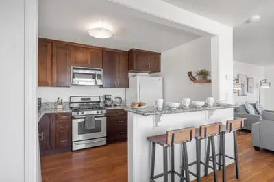 a kitchen with wooden cabinets and a white refrigerator at Coastal Sunsets in San Diego