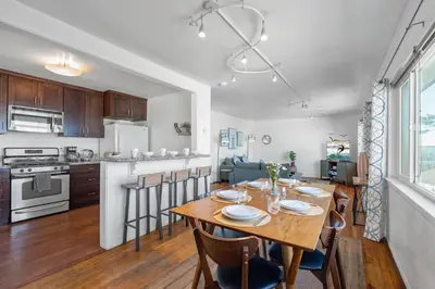 a kitchen and dining room with a wooden table and chairs at Coastal Sunsets in San Diego