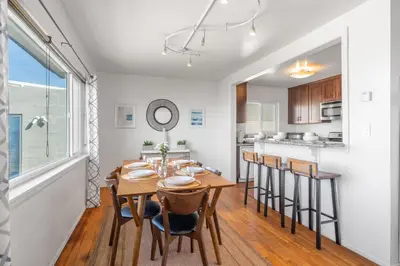 a kitchen and dining room with a wooden table and chairs at Coastal Sunsets in San Diego