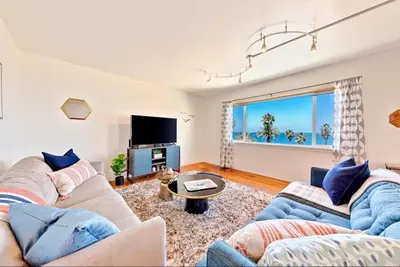 a living room with two couches and a tv at Coastal Sunsets in San Diego