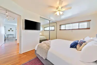 a bedroom with a white bed with a ceiling fan at Coastal Sunsets in San Diego