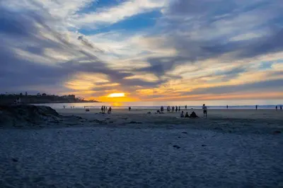 a group of people on a beach at sunset at Sand Patch in San Diego