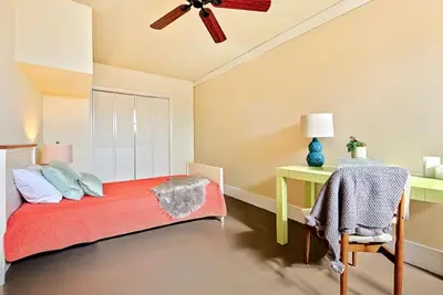 a bedroom with a red bed and a desk at Sand Patch in San Diego
