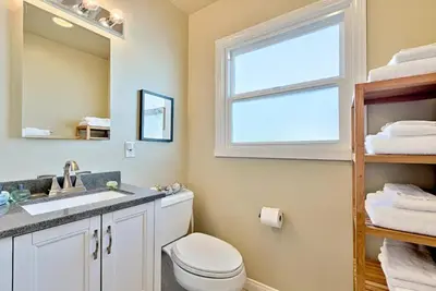 a bathroom with a toilet and a sink and a window at Sand Patch in San Diego