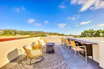 a patio with a table and chairs on a roof at Sunny Shores in San Diego