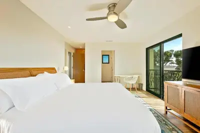 a bedroom with a white bed and a flat screen tv at Sunny Shores in San Diego