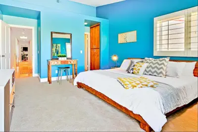 a blue bedroom with a bed and a desk at Bonair Beauty in San Diego