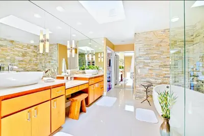 a bathroom with two sinks and a tub and a glass wall at Bonair Beauty in San Diego