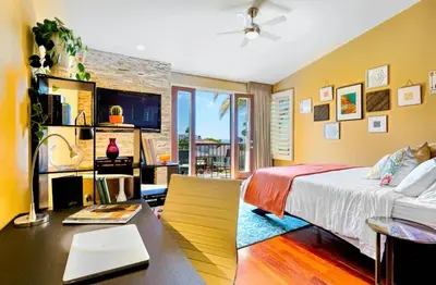 a bedroom with a bed and a desk with a laptop at Bonair Beauty in San Diego