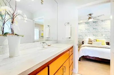 a bathroom with a sink and a large mirror at Bonair Beauty in San Diego