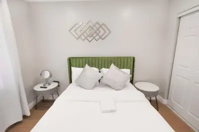 a bedroom with a white bed with a green headboard at 8354 Adam Unit A 2b 1b by sdstay in Lemon Grove