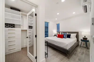 a bedroom with a bed and a walk in closet at Bayside Delight Just Steps to Water in San Diego