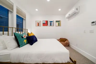 a bedroom with a bed with white sheets and pillows at Bayside Delight Just Steps to Water in San Diego