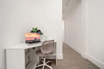 a white desk with a laptop and a chair at Bayside Delight Just Steps to Water in San Diego