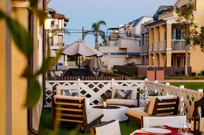 a patio with chairs and a fire pit on a balcony at Bayside Delight Just Steps to Water in San Diego