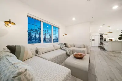 a white living room with a couch and a table at Bayside Delight Just Steps to Water in San Diego