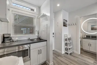 a white kitchen with a sink and a window at Ocean VIEWS! Steps from Victoria Beach, Lux Design in Laguna Beach