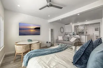 a living room with a bed and a table at Ocean VIEWS! Steps from Victoria Beach, Lux Design in Laguna Beach