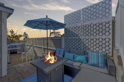 a patio with a couch and an umbrella and a fire pit at Ocean Views! Detached Villa by Victoria Beach in Laguna Beach