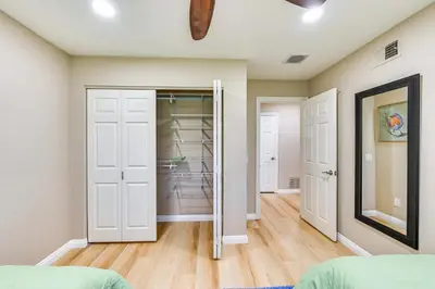 a room with a closet with white doors and wood floors at 13 Mi to Downtown San Diego Quiet Home with Spa! in Chula Vista