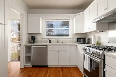 a white kitchen with white cabinets and a window at Falcon Chic Escape - Hot Tub - Modern - Proximity in San Diego