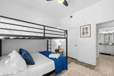 a bedroom with a bunk bed with blue pillows at King Bed, Pool, Hot Tub, Arcade Room, Gym, Parking in San Diego