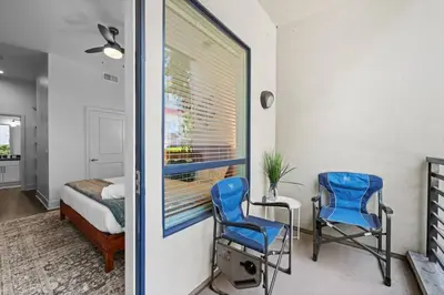 two blue chairs in a room with a bed and a window at King Bed, Pool, Hot Tub, Arcade Room, Gym, Parking in San Diego