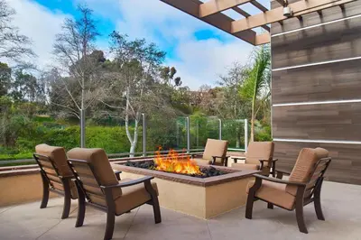 a patio with four chairs and a fire pit at Fairfield Inn & Suites by Marriott San Diego Carlsbad in Carlsbad