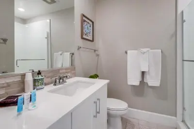 a white bathroom with a sink and a toilet at Steps 2 Ocean & Bay Luxury Belmont Park Dining in San Diego