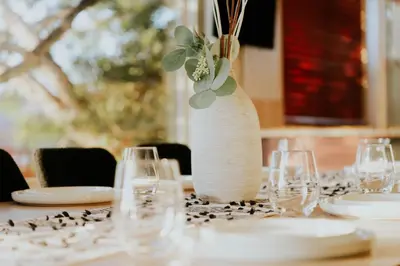 a table with glasses and a vase with flowers on it at Family-Friendly Bay Views, Game Room, Hot Tub! in San Diego