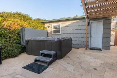 a backyard with a hot tub and a grill at Family-Friendly Bay Views, Game Room, Hot Tub! in San Diego