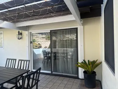 a screened porch with a table and chairs and a dining room at Mount Helix Villa in El Cajon
