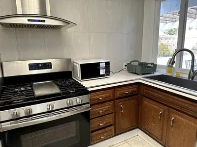 a kitchen with a stove and a microwave at Mount Helix Villa in El Cajon