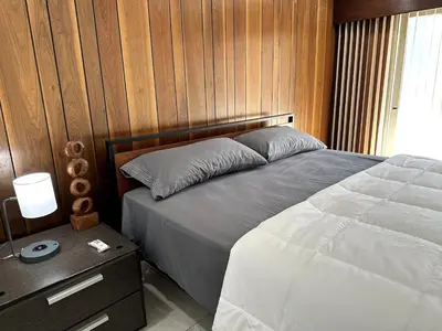 a bedroom with a bed and a wooden wall at Mount Helix Villa in El Cajon