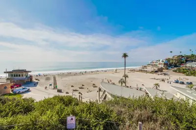 a beach with a lot of people and the ocean at Ocean Views Moonlight Beach Ocean Deck Pool Hot Tub in Encinitas