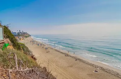 a beach with a lot of people and the ocean at Ocean Views Moonlight Beach Ocean Deck Pool Hot Tub in Encinitas