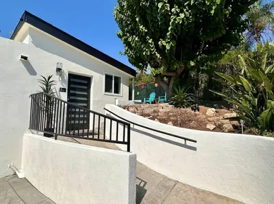 a white house with a staircase leading to a yard at Casa Agave, 2 Bedroom, 1 Bath Guest House, with 3 Beds & Game Room in Vista