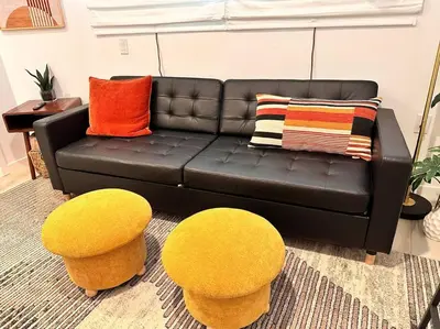 a living room with a black couch and two yellow stools at Casa Agave, 2 Bedroom, 1 Bath Guest House, with 3 Beds & Game Room in Vista