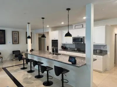 a kitchen with a bar with chairs and a counter top at Elegant Retreat with Private Luxurious Gen Suite in Menifee