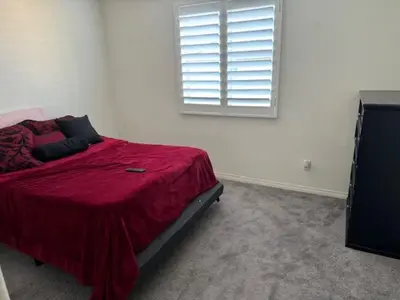 a bedroom with a bed with a red blanket and a window at Elegant Retreat with Private Luxurious Gen Suite in Menifee