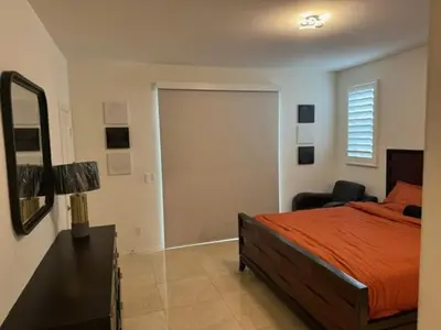 a bedroom with a bed and a mirror and a chair at Elegant Retreat with Private Luxurious Gen Suite in Menifee