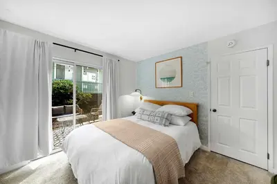 a bedroom with a bed and a large window at Beacons Beach Cottage in Encinitas