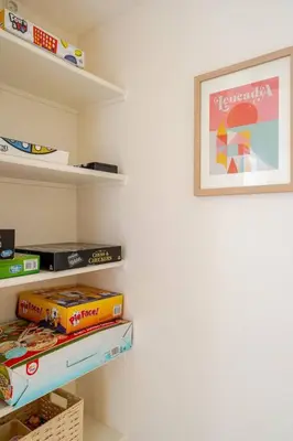 a shelf with a picture on a wall with books at Beacons Beach Cottage in Encinitas