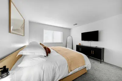 a bedroom with a bed and a flat screen tv at Leucadia's Beach House w Game Room in Encinitas