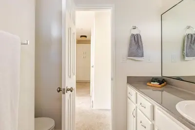 a bathroom with a sink and a toilet and a mirror at Leucadia's Beach House w Game Room in Encinitas