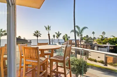 a balcony with a table and chairs and the ocean at Oceanview Townhome Just Steps from Iconic Windansea Beach in San Diego
