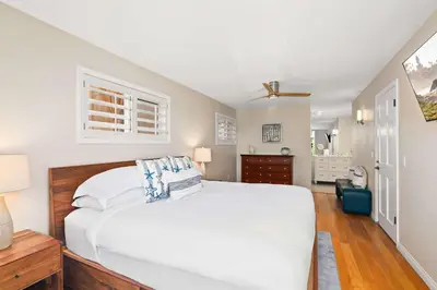 a bedroom with a large white bed with blue pillows at Oceanview Townhome Just Steps from Iconic Windansea Beach in San Diego