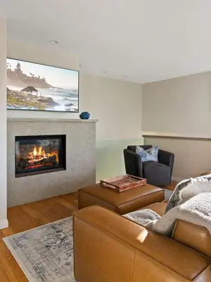 a living room with a couch and a fireplace at Oceanview Townhome Just Steps from Iconic Windansea Beach in San Diego